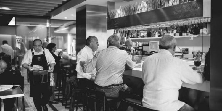 «DISCULPA QUE TE DE LA ESPALDA…» Elogio a la soledad tumultuosa de una barra de bar.